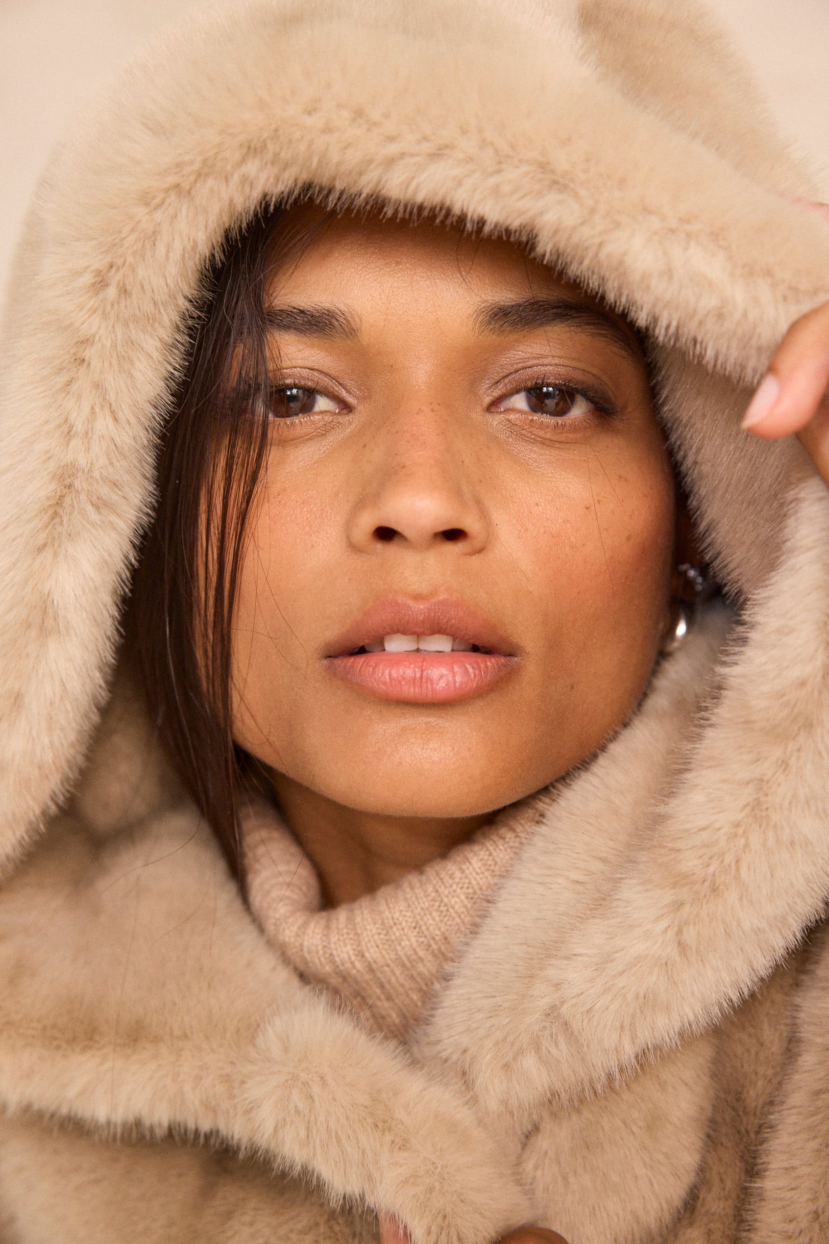 Femme portant une capuche en fausse fourrure beige
